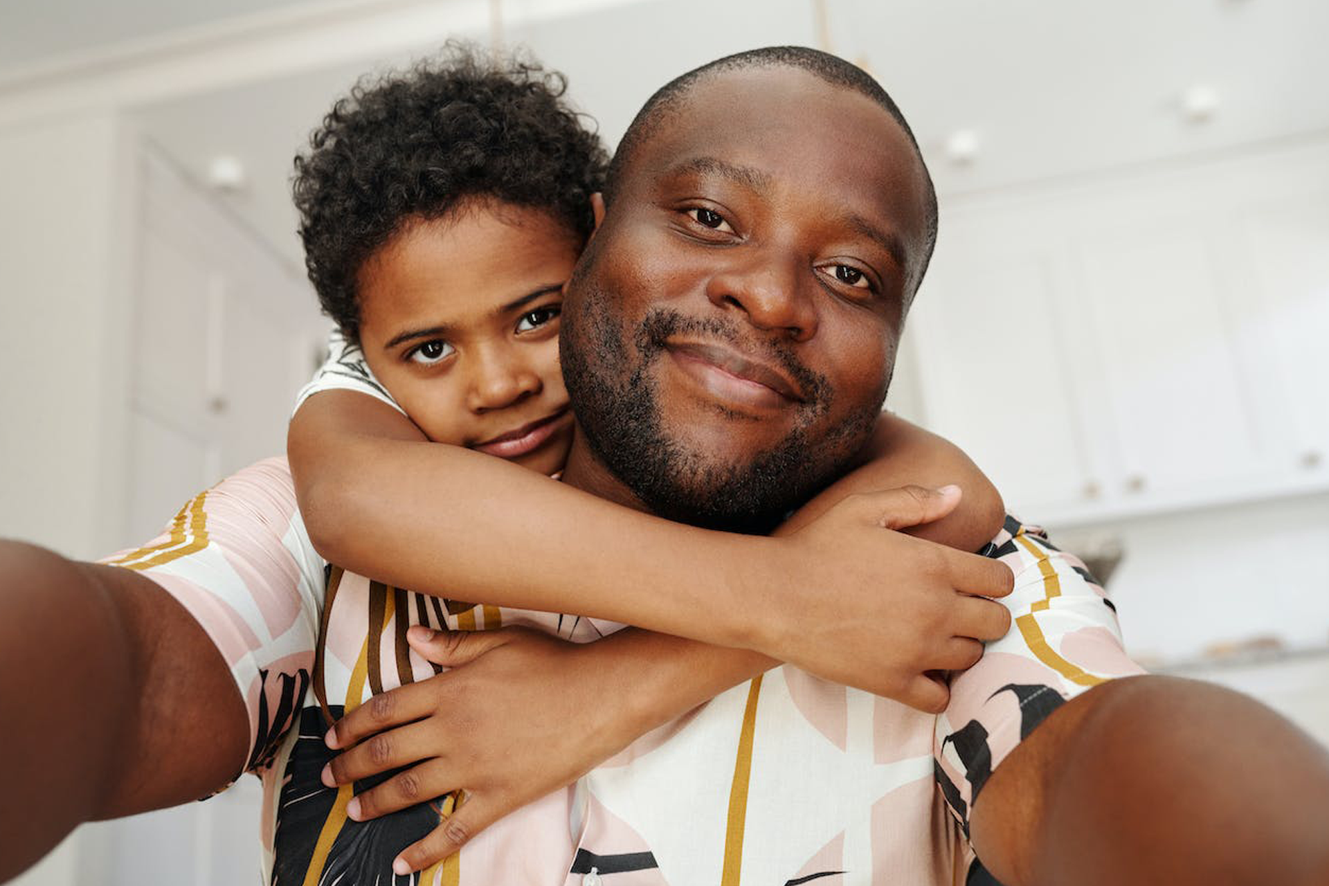 Black son hugging his black father.