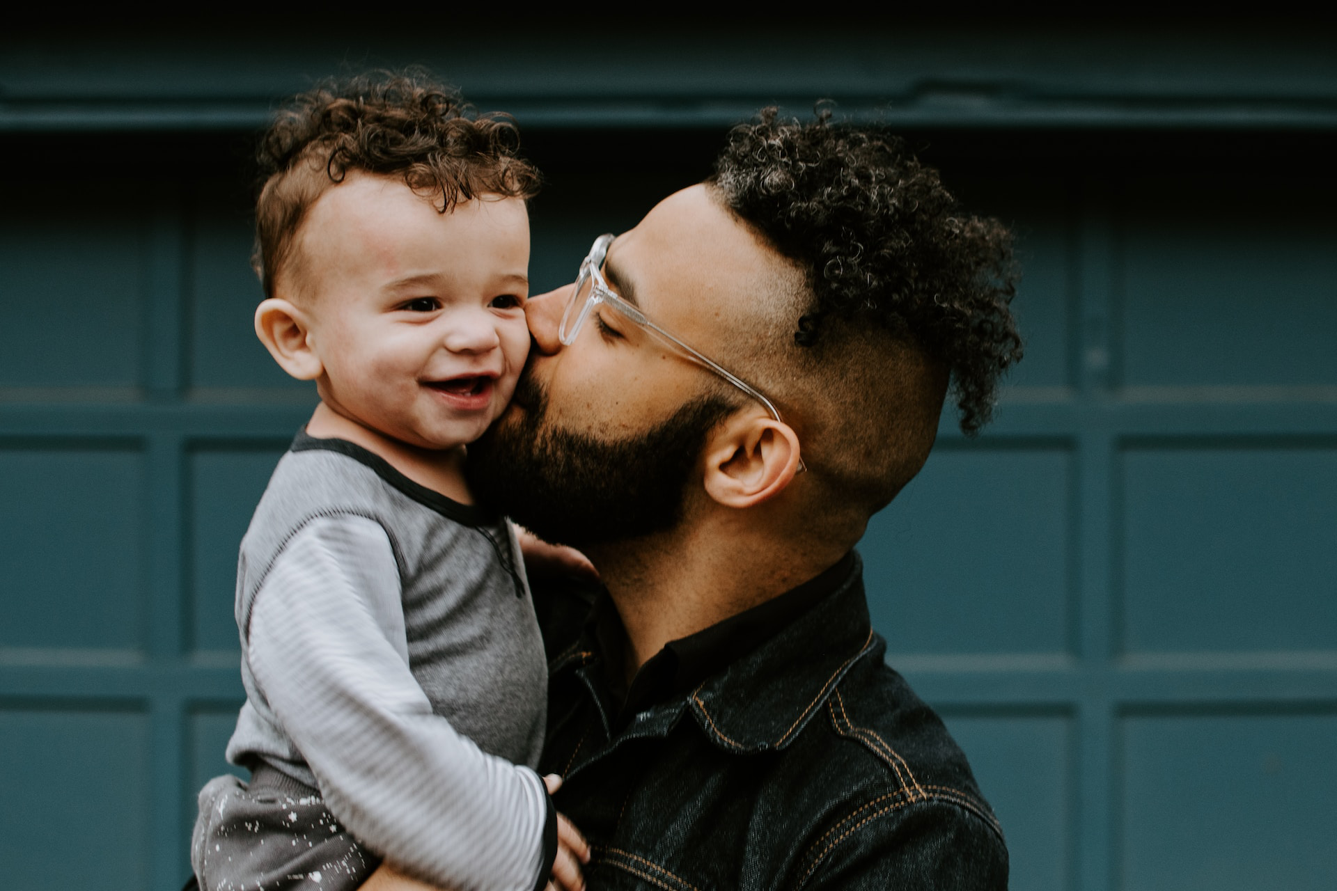 Hispanic dad kissing his child.